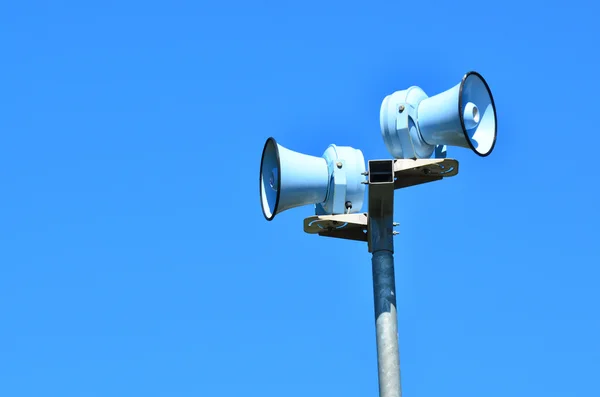 Air raid siren tegen blauwe hemel — Stockfoto