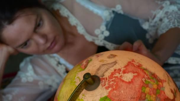 Jonge vrouw Zoek reizen bestemming vintage globe — Stockvideo