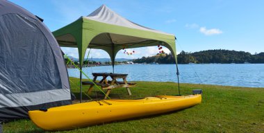 Kayak and tent in Sandspit beach New Zealand clipart