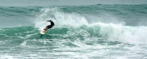 Hombre surfeando en Tawharanui Regional Park Nueva Zelanda — Foto de Stock