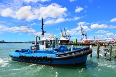 Tugboat works at Captain Cook Wharf in Ports of Auckland, New Ze clipart