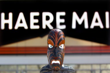 Maori sculpture under sign reads Welcome in Maori  clipart