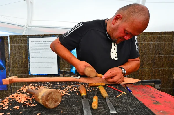 Maori man rista en Maori Wood carving — Stockfoto