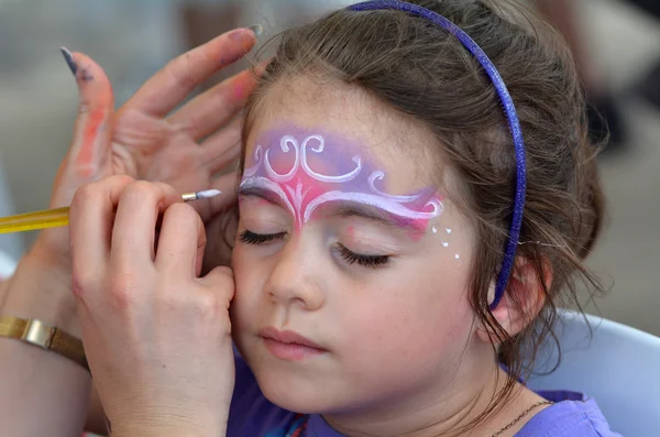 Kleines Mädchen lässt sich von Kinderschminker schminken — Stockfoto