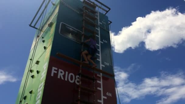 Mädchen klettert auf Leiter an hohe senkrechte Wand — Stockvideo