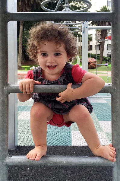 Kleines Mädchen klettert auf Leiter auf Spielplatz — Stockfoto
