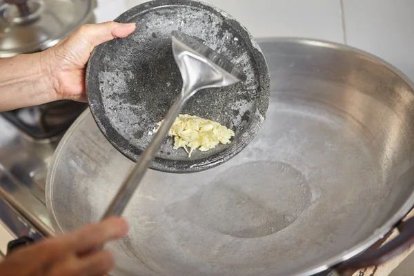 Toevoegen van geplette knoflook — Stockfoto