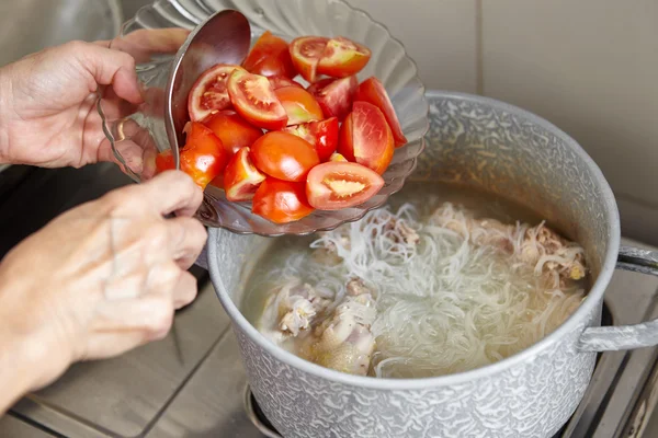 鍋で料理にトマトを追加します。 — ストック写真