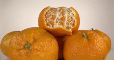 Mandalina Yığını. Kamera yavaşça soyulmuş mandalinaya yaklaşır ve mandalina kümesinin üzerinde durur..