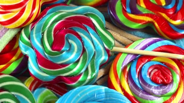 多彩的糖果棒棒糖在桌子上旋转着 — 图库视频影像