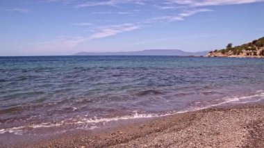 Ada Kayalıkları ve Deniz Pelerini 'nin Dolly Shot' u. Mavi Okyanus Dalgaları ve Taşlar Manzarası.