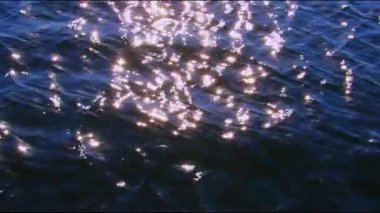 Okyanus yüzeyine yansıyan güneşten parlayan parıltılar.