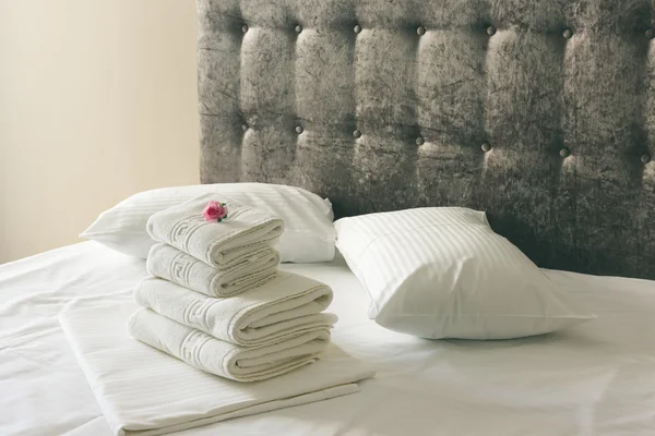 Lenzuola bianche con letto marrone in camera d'albergo — Foto Stock
