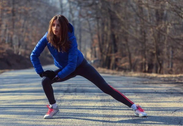 Mulher se aquecendo para correr de manhã na natureza — Fotografia de Stock