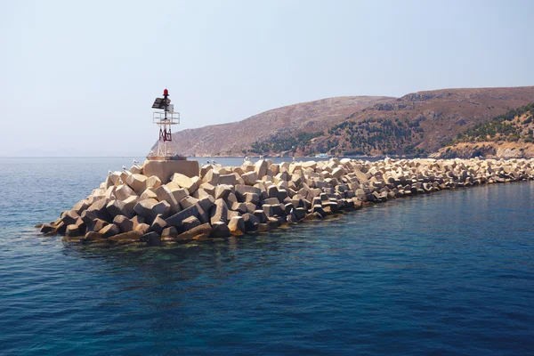 Massiver Betondamm auf See nahe Insel lizenzfreie Stockfotos