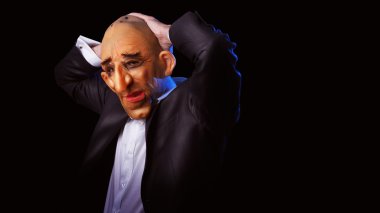 Korkunç adam kafasını tutarak maske ile takım elbiseli