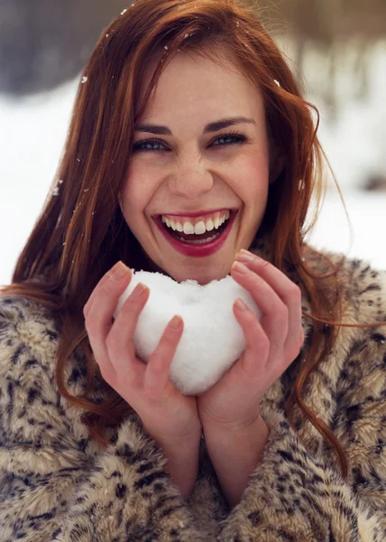 Красива жінка тримає снігове серце — стокове фото