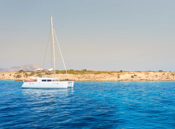 Barco à vela flutuando no mar perto da ilha — Fotografia de Stock