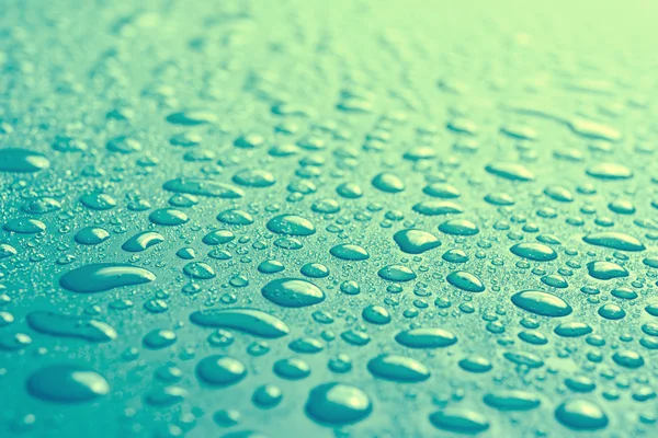 Water drops on blue surface with small depth of field — Stock Photo, Image