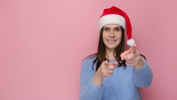 Leuke Jonge Vrouw Met Rode Kerstmuts Wijst Naar Wijst Opzij — Stockvideo