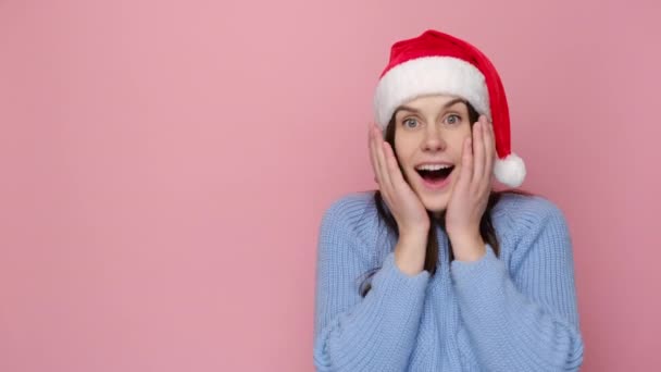Emocionální Usmívající Mladá Žena Vánočním Červeném Klobouku Šokovaným Výrazem Drží — Stock video