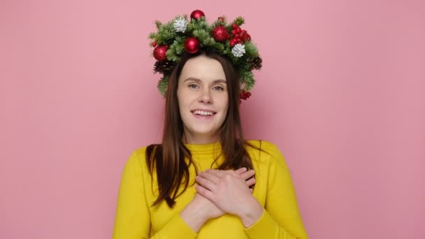 Mulher Olhando Amigável Grinalda Natal Tradicional Mantém Mãos Peito Sente — Vídeo de Stock