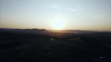 Güzel günbatımında sonbahar ormanları ve kırsal bölgelerde uçuşun insansız hava aracı görüntüsü. Arka planda sıradağlar var. Gezgin şehvet, büyüleyici ve ürkütücü doğa.