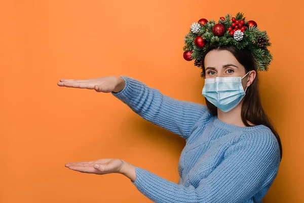 의료용 마스크를 여성의 스튜디오 물체를 오렌지 손바닥을 휴가용 화환을 머리에 — 스톡 사진