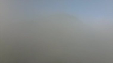 Güneşli kış gününde dağ zirvesi ve bulutların hava aracı görüntüsü. Heyecan verici ve büyüleyici sakin sakin bir uçuş sahnesi. Açık hava yaşam tarzı sağlıklı ve temiz hava için. Gezgin şehvet hedefi