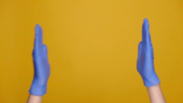 将男性的双手紧握在医用防护手套中 展示出巨大的体形 展示出一些宽阔的东西 在黄色的工作室背景下与广告的复制空间隔离 身体语言概念 — 图库视频影像