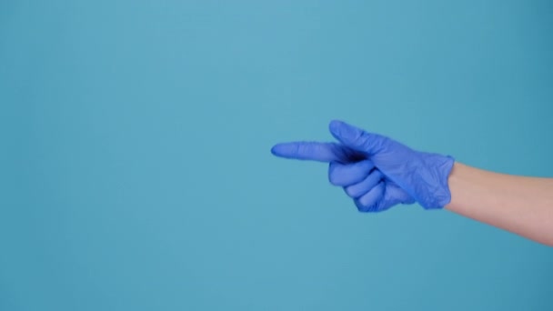 医療用保護手袋で女性の手のクローズアップジェスチャーを作る青の背景に隔離された近くに来てください ボディランゲージとCovid 19のコンセプト テキストや画像 プロモーションコンテンツの場所で — ストック動画