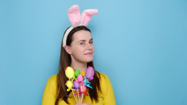 Positieve Jonge Vrouw Houdt Kleine Kleurrijke Eieren Wijst Met Verhoogt — Stockvideo