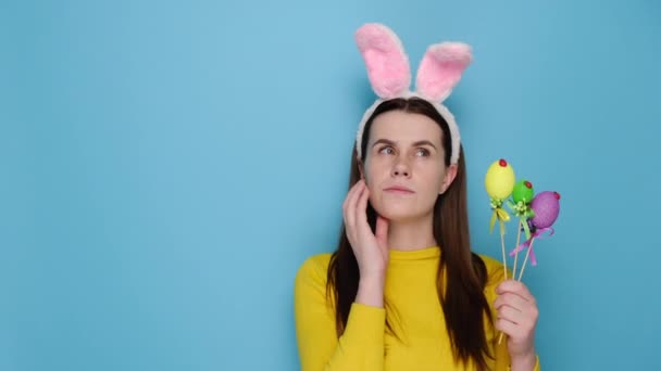 Pensando Mujer Joven Rosa Conejito Orejas Esponjosas Sostiene Huevos Pintados — Vídeos de Stock