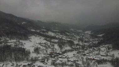 Şiddetli kar yağışı sırasında kırsal araziyi ya da fırtınalı kar fırtınasını gösteren insansız hava aracı görüntüsü. Turizm ve gezgin şehveti için keşif ve seyahat yeri. Ağaç tepeleri göze çarpar