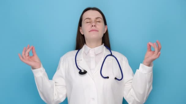 冷静而耐心的女医生 身着制服的护士保持放松 闭目沉思 笑容满面 与蓝色背景隔离 Covid 保健工作者和预防病毒概念 — 图库视频影像