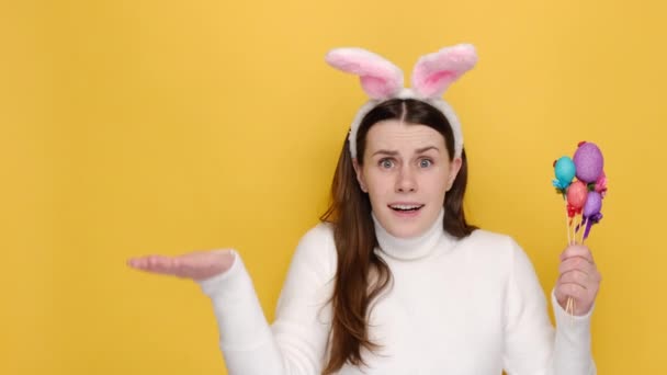 Rozhořčená Nespokojená Brunetka Roztahuje Ruku Drží Malovaná Vajíčka Oblečená Bílém — Stock video