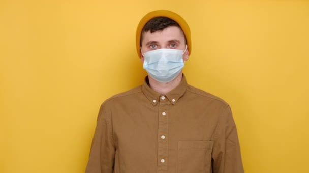 의료용 마스크를 남자가 배경에 고립된 모자를 크기의 복사본 공간을 시연하는 — 비디오
