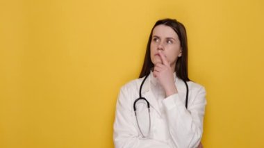 Meditasyon pozitifliği ile düşünen ilham verici kadın doktor, harika bir fikir çözümü ile parmak kaldırma, cevap, kopyalama alanını işaret etmek, yaratıcı düşünce, sarı duvarda izole edilmiş.