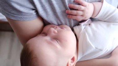 Sevecen genç annenin, uyuyan sevimli bebeğe şefkatle sarılışının yakın portresi. Annesinin kollarında uyuyan komik yeni doğmuş bebek. Annesi ve küçük sağlıklı çocuğu. Aşk, bağlılık, mutlu aile kavramı