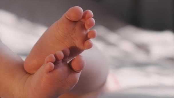 Закройте Красивые Ласковые Ноги Новорожденной Девочки Лежащей Дома Удобной Кровати — стоковое видео
