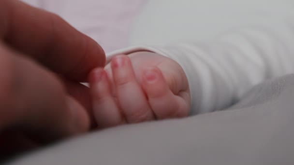 Close Irreconhecível Carinhoso Jovem Pai Segura Toca Mão Bebê Deitado — Vídeo de Stock