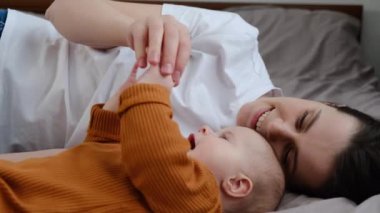 Sevgi dolu bekar bir anne ve tatlı bir kız bebek rahat bir yatakta uzanıyor, aşkın tatlı anının tadını çıkarıyor. Genç, gülümseyen anne, tatlı çocukla oynaşıyor. Yatak odasında birlikte güzel vakit geçiriyorlar.