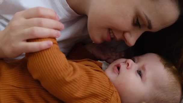 Şefkatli Anne Tatlı Bebeğin Evdeki Rahat Yatakta Uzanmış Burnuna Dokunması — Stok video