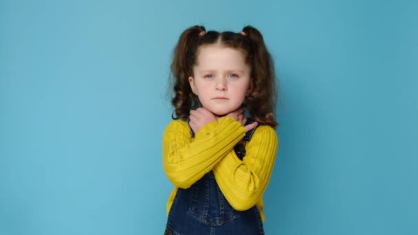 不健康な女の子の子供のタッチ首を飲み込むのは難しい痛みを感じる不快感 喉の痛み刺激や声の損失 青いスタジオの背景上のモデル 扁桃炎狭心症の概念 — ストック動画