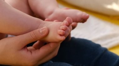 Değer veren genç bir anne, güzel bacaklı kızını kucağına alır çocuk odasında rahat bir çadırda oturur, beyaz bir anneyi sever ve küçük bir kız çocuğu da eğlenmekten zevk alır. Yavaş çekim. Annelik kavramı