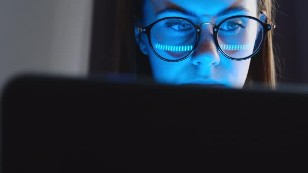 안경을 여성은 노트북 화면을 보면서 노트를 집에서 기술을 공부하는 고민합니다 — 비디오