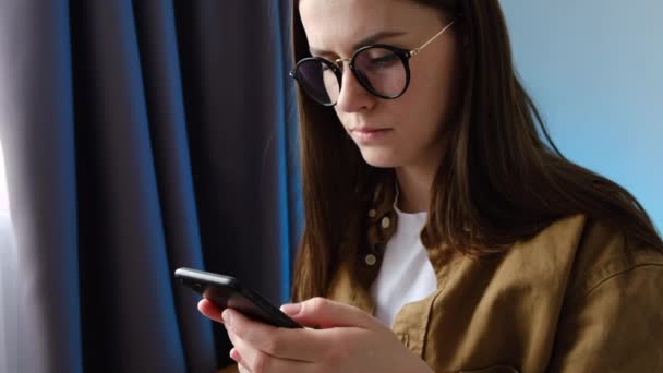 Concepto Websurf Mujer Joven Gafas Sientan Cama Sosteniendo Teléfono Inteligente — Vídeo de stock