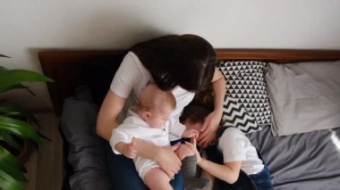 Sevgi dolu genç bir annenin kucağına yatıp uyuyan kızıyla kucaklaşması, mutlu beyaz bir annenin sarılıp yatması, iki küçük kız kardeşi kucaklaması, hassas anın tadını çıkarması.