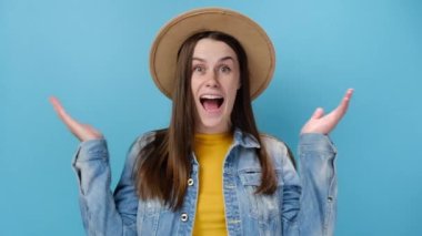 Yan görünüşlü, şaşırmış bir kadın model ağzını kapatan kameranın etrafında dönüp ellerini açıp 