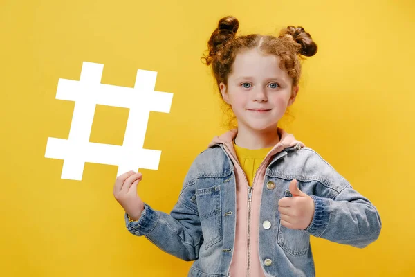 Bonito Criança Menina Caucasiana Segurando Grande Símbolo Hashtag Branco Apontando — Fotografia de Stock
